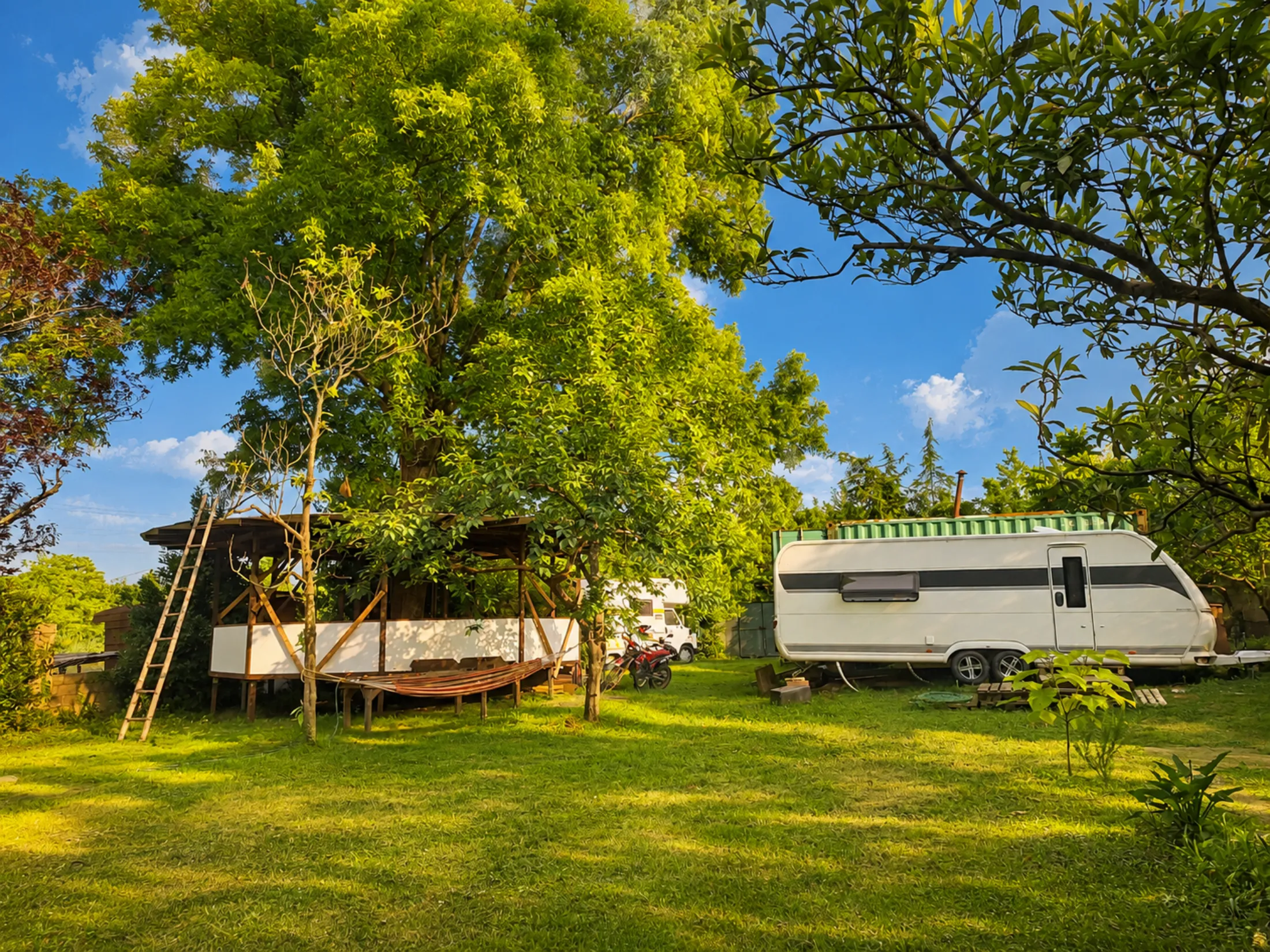 The Firefly Caravan and shaded deck in the green garden at Nomad Garden, Poti